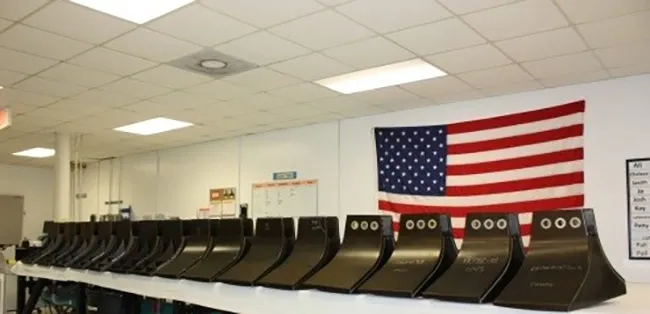 A row of voting machines in front of an american flag.